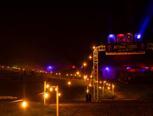 SCREAMS! at Thornton Hall Country Park Entrance Experience Entrance pathway illuminated with glowing lights leading to SCREAMS! at Thornton Hall Country Park Halloween scare attractions at night.